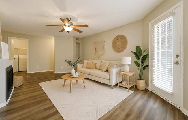 A living room with a white couch and a wooden coffee table.