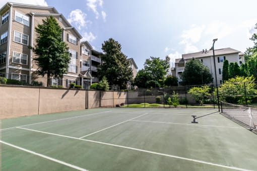 a tennis court with apartments in the background