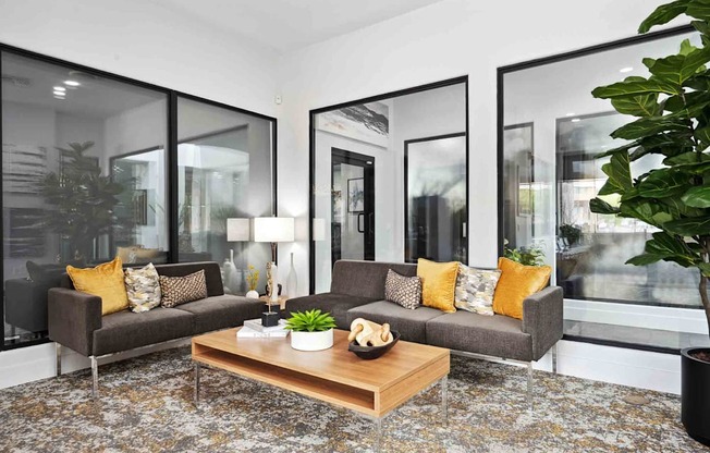 a living room with gray couches and a wooden coffee table on top of a rug