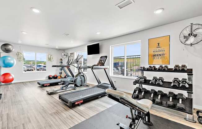 a workout room with treadmills and other exercise equipment