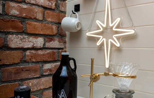 a christmas ornament hanging from a brick wall next to a table with a candle