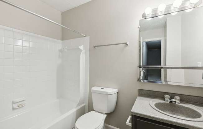 a bathroom with a toilet sink and shower and a mirror