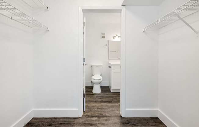 a white bathroom with a toilet and a closet