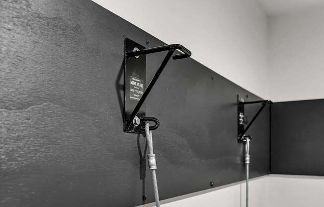 A black and white photo of a wall-mounted monitor with a cable attached to it.