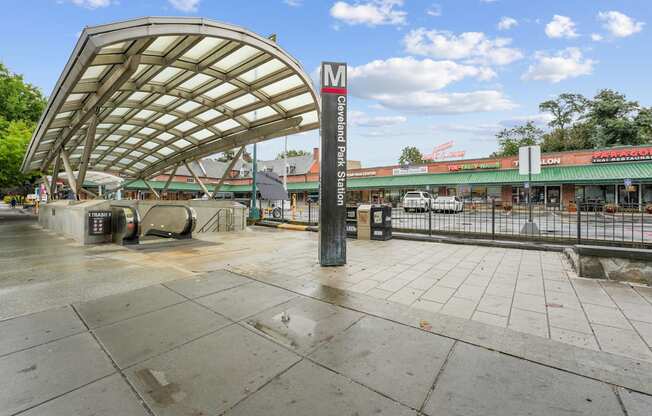 A wet sidewalk leads to a bus stop shelter.