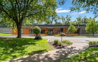 A building with orange walls and a green lawn in front.