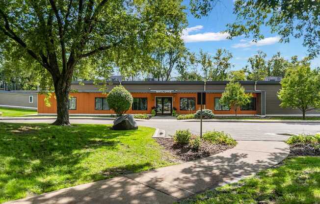 A building with orange walls and a green lawn in front.