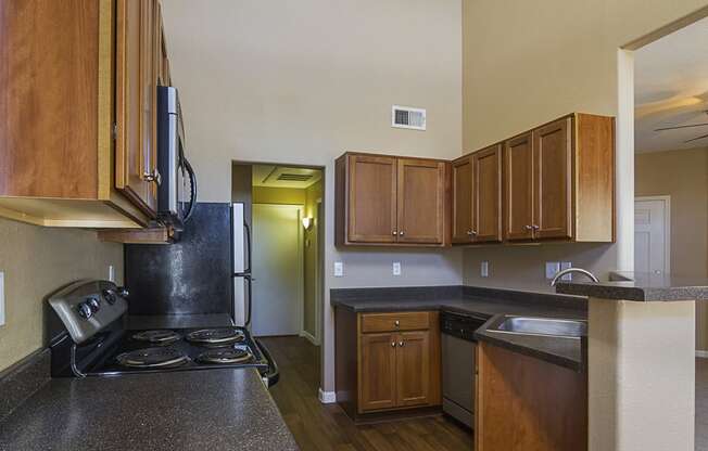 Kitchen with black laminate countertops and walnut stained flat panel cabinet fronts