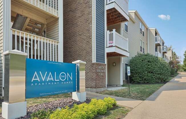 an apartment building with a blue sign that reads avalon apartment yards