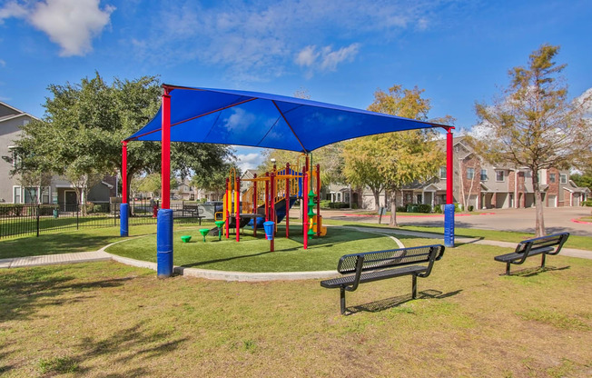 a playground with a blue canopy and benches in a park at Sladestone Shadow Creek, Pearland, TX, 77584