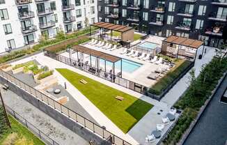 an aerial view of an apartment complex with a pool and grassy area