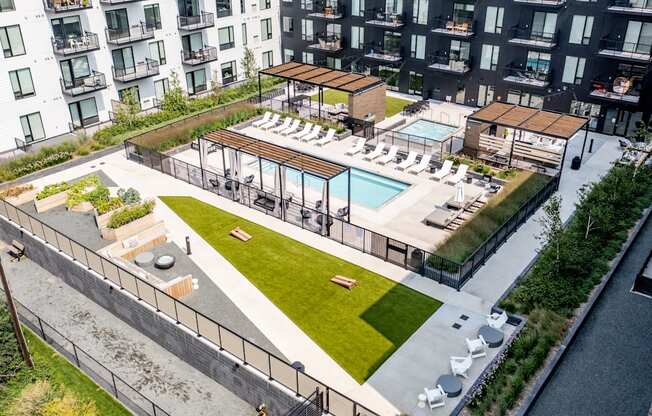 an aerial view of an apartment complex with a pool and grassy area