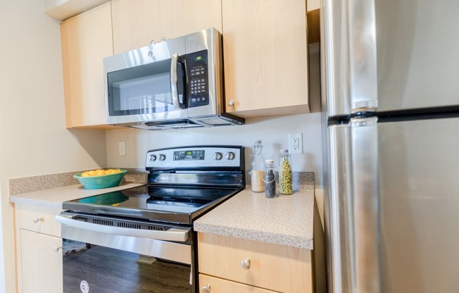 a kitchen with wooden cabinets and stainless steel appliances at Heritage Bay, Jensen Beach, 34957