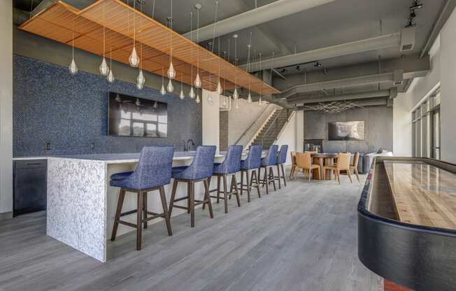 a lobby with bar stools and chairs and a bar with a counter