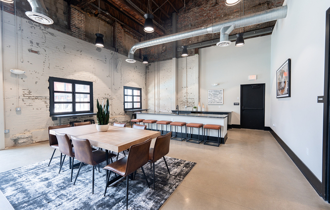 Modern loft-style dining and kitchen area with exposed brick