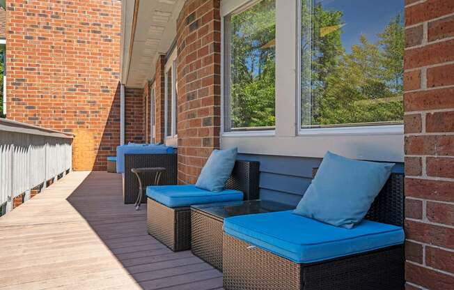 a porch with wicker furniture and blue cushions
