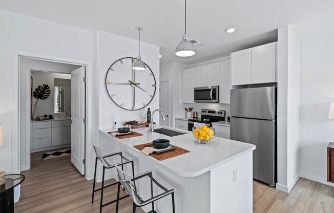 an open kitchen with a large clock on the wall at Altis Grand Suncoast, Land O' Lakes, FL