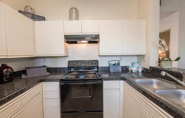 A black stove top oven in a kitchen with white cabinets at Autumn Oaks Apartments, Roseville, CA, 95678