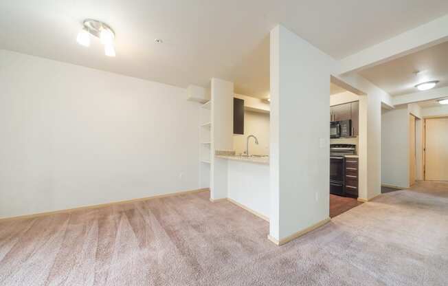 a living room with white walls and carpet