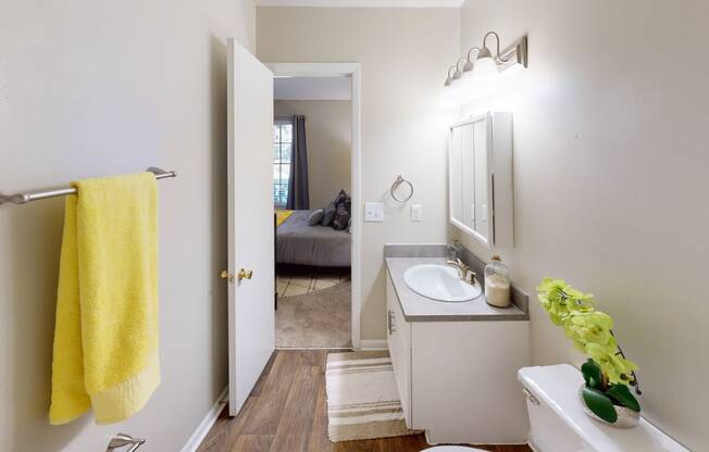 a bathroom with a white sink and a yellow towel