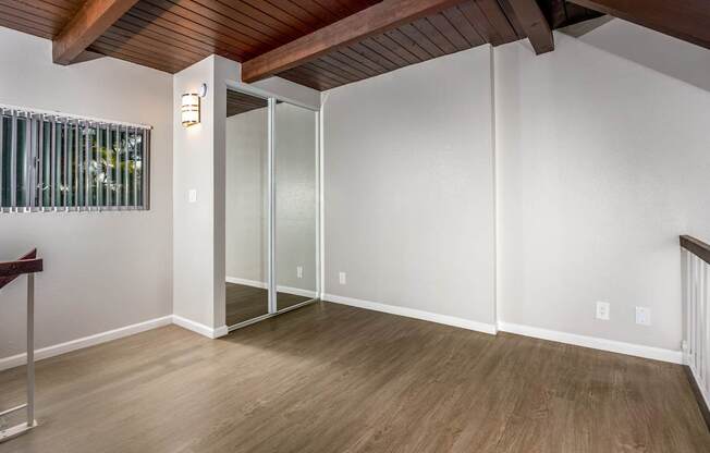 A room with a wooden ceiling and a glass door.