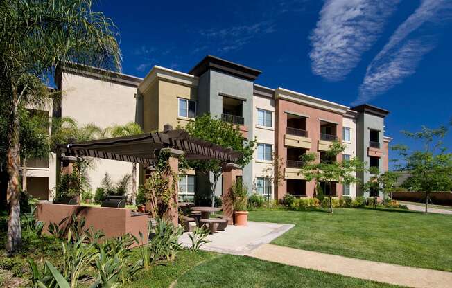 Apartment complex with a green lawn in front at The Kitt at Warner Center Apartments, California