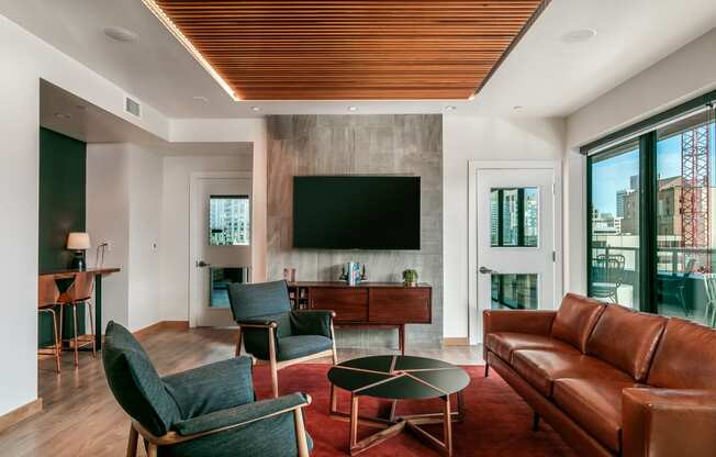 a living room with a leather couch and chairs and a television