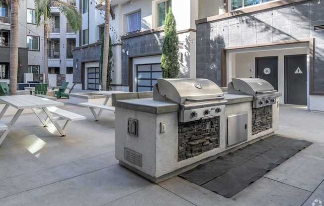A modern outdoor kitchen with a grill and sink.