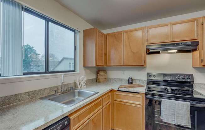 A kitchen with wooden cabinets and a black stove top oven.