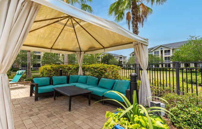 a patio with a gazebo and couches and a table
