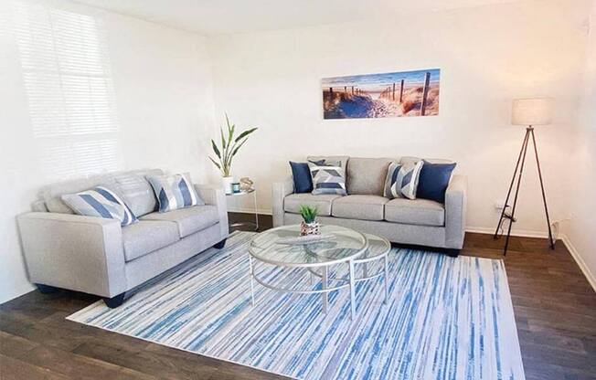 a living room with two couches and a glass table