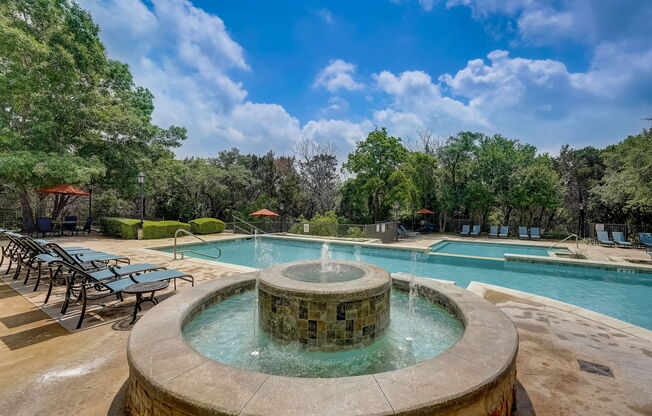 a swimming pool with a fountain in the middle