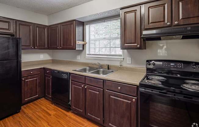 a kitchen with a sink and a stove and a window