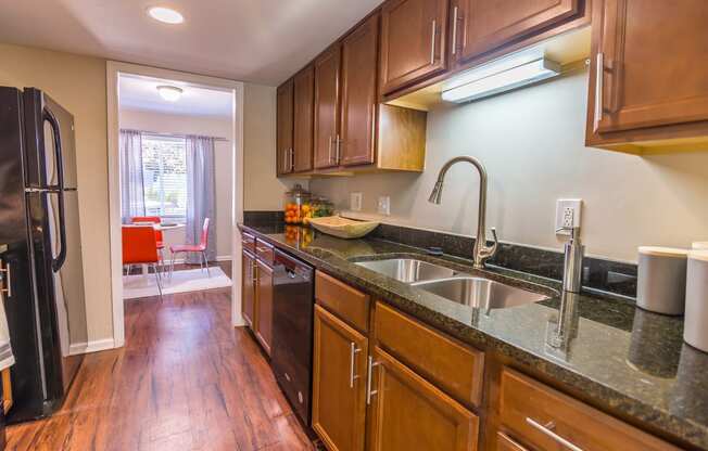 a kitchen with wood cabinets and granite countertops at Broadway at East Atlanta, Atlanta, GA, 30316