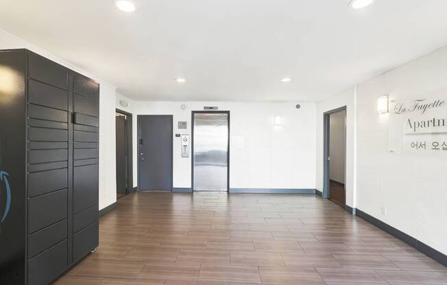 A hallway with a black cabinet on the left and a white wall with a sign that reads "In-Foyette Apartments".