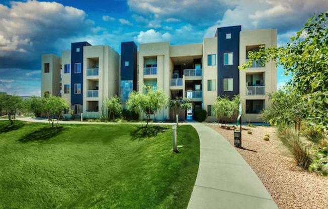 A modern apartment complex with a green lawn in front.