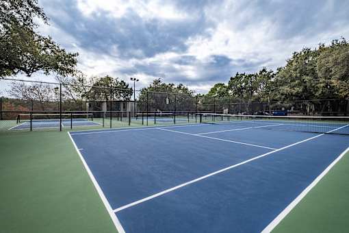 A tennis court with a blue surface and white lines.