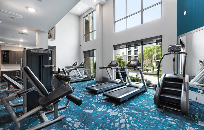 Two-story fitness center with cardio machines and free weights at Cyan Craig Ranch apartments for rent