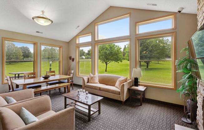 a living room with couches and tables and large windows