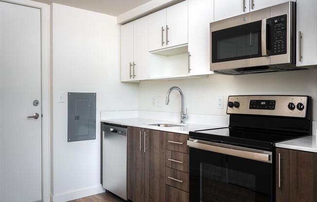 a kitchen with white cabinets and black appliances and a microwave