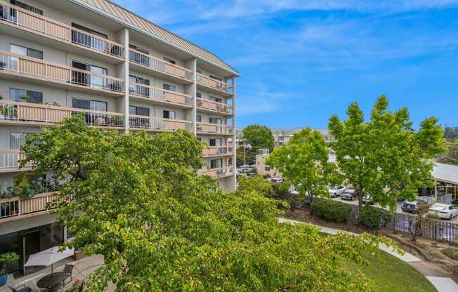 a view of an apartment building with trees in front of it