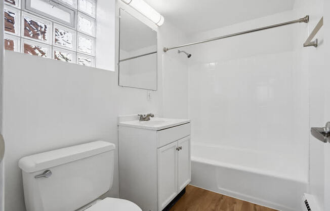 A white bathroom with a toilet, sink, and bathtub.