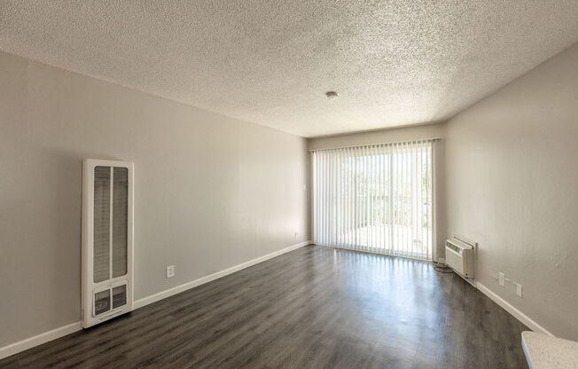 the living room and dining room of an empty house with wood flooring