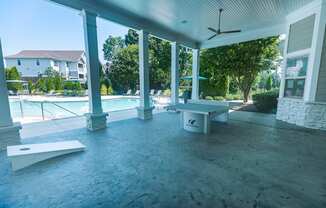A poolside patio with a table and chairs.