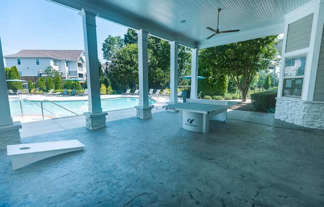A poolside patio with a table and chairs.