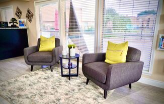 a living room with two chairs and a table