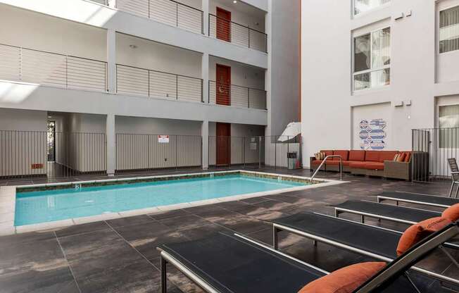A large indoor swimming pool with a black metal railing.