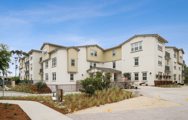 a row of apartment buildings with a sidewalk in front of them