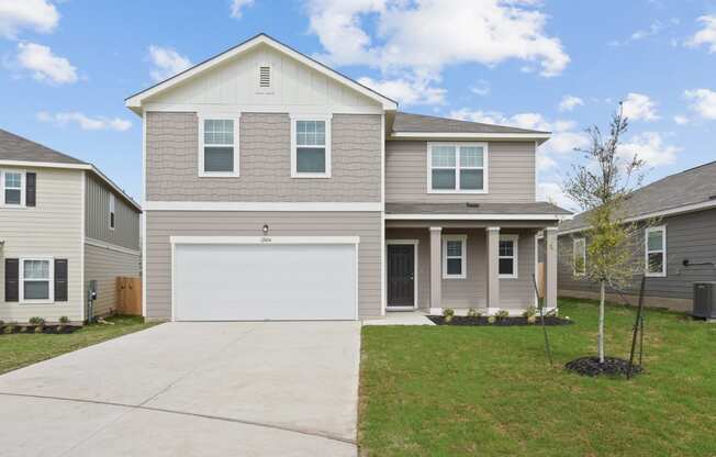 a house with a white garage door in front of a green lawn at Beacon at Presidential Heights, Manor Texas