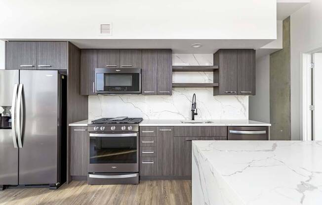 Stainless steel appliances featuring side-by-side refrigerator with ice maker and kitchen island in some homes*